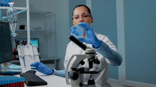 Portrait of young woman using mobile phone in laboratory