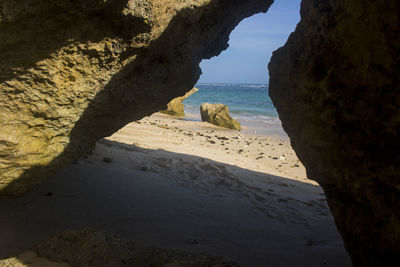 Rock formation on beach against sky