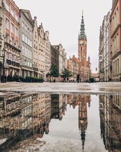 Buildings reflecting on puddle