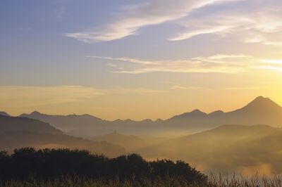 Scenic view of silhouette mountains against sky at sunset