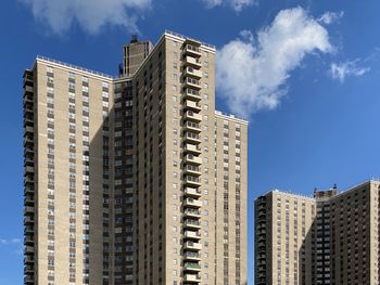 Low angle view of modern buildings against blue sky