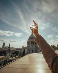 Woman pointing towards sky in city