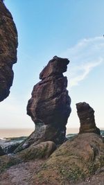 Rock formation in sea against sky