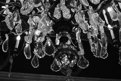 Low angle view of illuminated light bulb hanging on ceiling