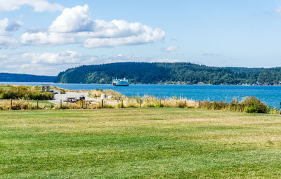 A ferry leaves port near dune peninsula park in ruston, washington.