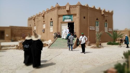 People walking on building against sky