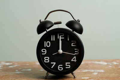 Close-up of clock on table against wall