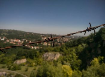 Close-up of barbed wire against sky