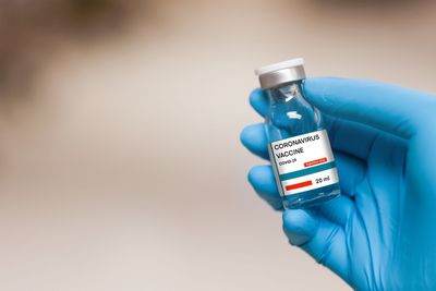 Close-up of hand holding bottle against blue background