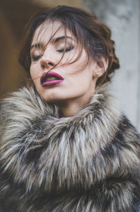 Portrait of woman with red eyes closed in winter