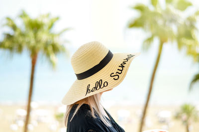 Rear view of woman wearing hat against trees