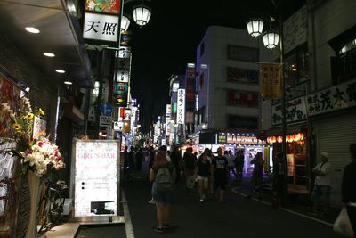 Crowd hanging on illuminated city at night