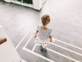 Rear view of boy walking on footpath