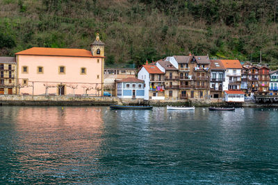 Buildings by river in town