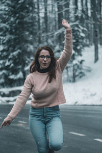 Young woman standing on snow covered tree