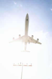 Low angle view of airplane flying against sky