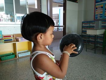 Side view of girl holding ball
