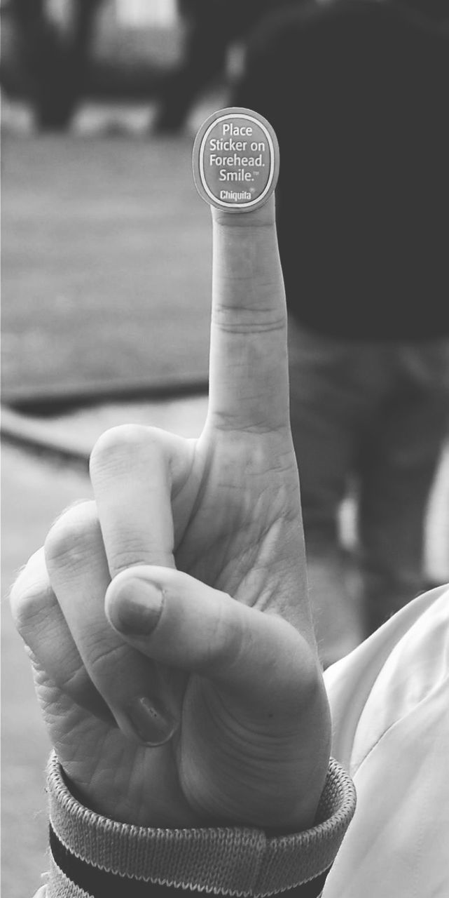 person, focus on foreground, lifestyles, holding, part of, leisure activity, men, close-up, cropped, human finger, personal perspective, low section, selective focus, sitting, outdoors, day