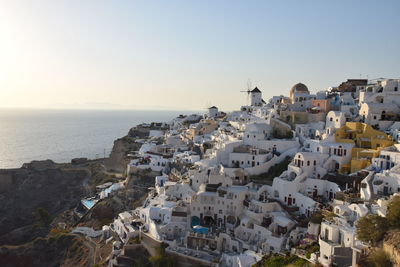 High angle view of townscape by sea against clear sky