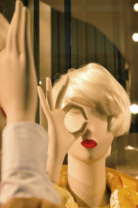 Close-up of mannequin by mirror at shop