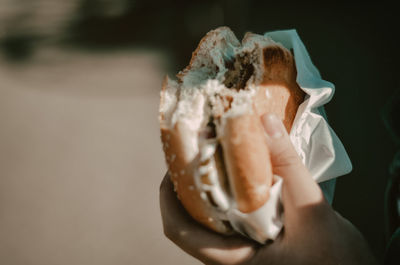Cropped hand of woman holding burger
