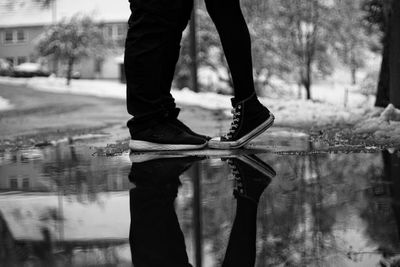 Low section of couple standing by puddle