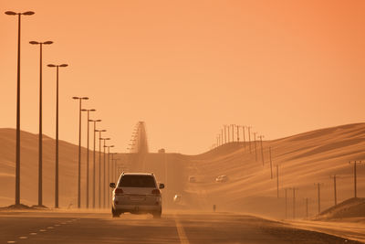 Car on street against sky during sunset