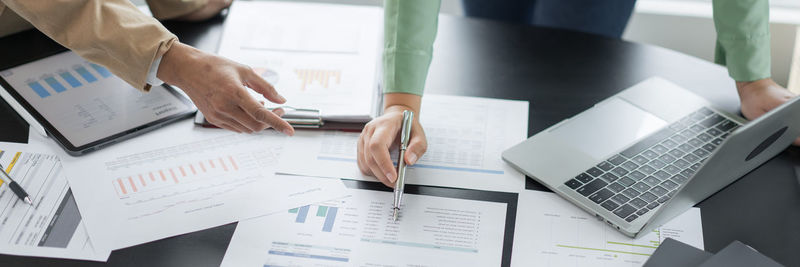 Midsection of business colleagues working on table