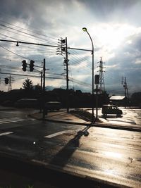 Silhouette of electricity pylon against cloudy sky