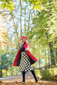 Full length of woman standing on autumn leaves