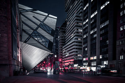 Low angle view of illuminated buildings against sky at night