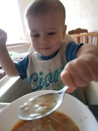 Boy holding ice cream on table