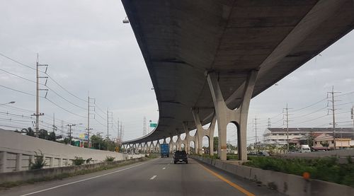 Bridge over highway in city against sky