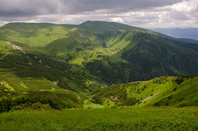 Scenic view of valley and mountains against sky