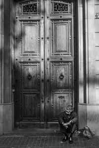 Man sitting against closed door