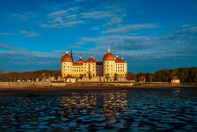 Building at waterfront against cloudy sky