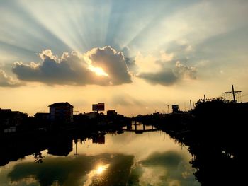 Silhouette city against sky during sunset