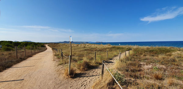 Scenic view of land by sea against sky