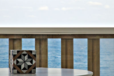 Close-up of table by sea against sky
