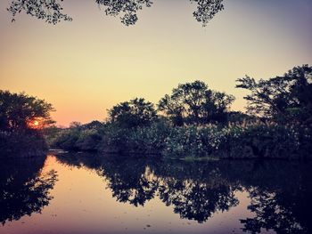 Scenic view of lake against sky at sunset