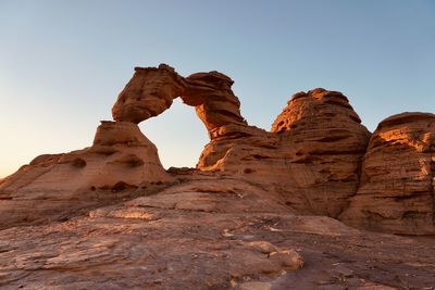 Low angle view of rock formations against clear blue sky