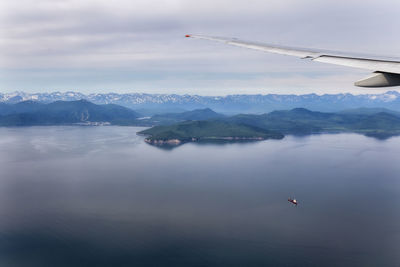 Aerial view of sea and mountains against sky