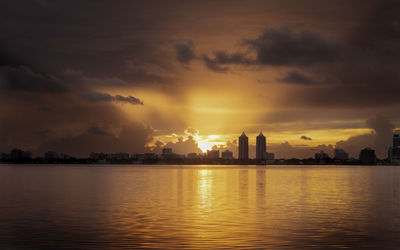Scenic view of silhouette city against sky during sunset