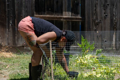 Portrait of young man standing by fence