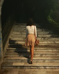 Rear view of woman walking on staircase