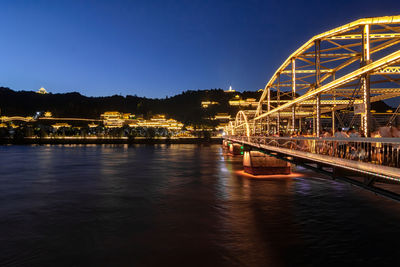 Illuminated bridge over river against sky at night in lanzhou