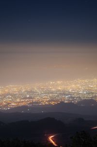 Aerial view of illuminated cityscape against sky at night