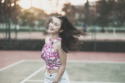 Portrait of smiling young woman standing outdoors