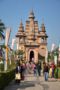 Group of people in front of building against clear sky