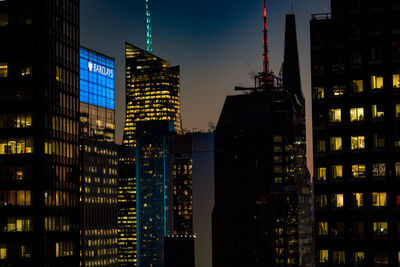 Illuminated buildings in city against sky at night